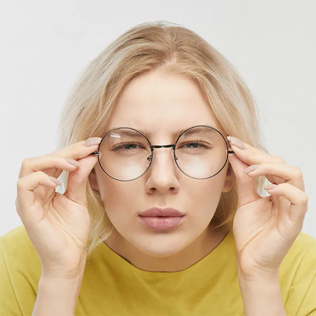 squinting woman adjusting glasses